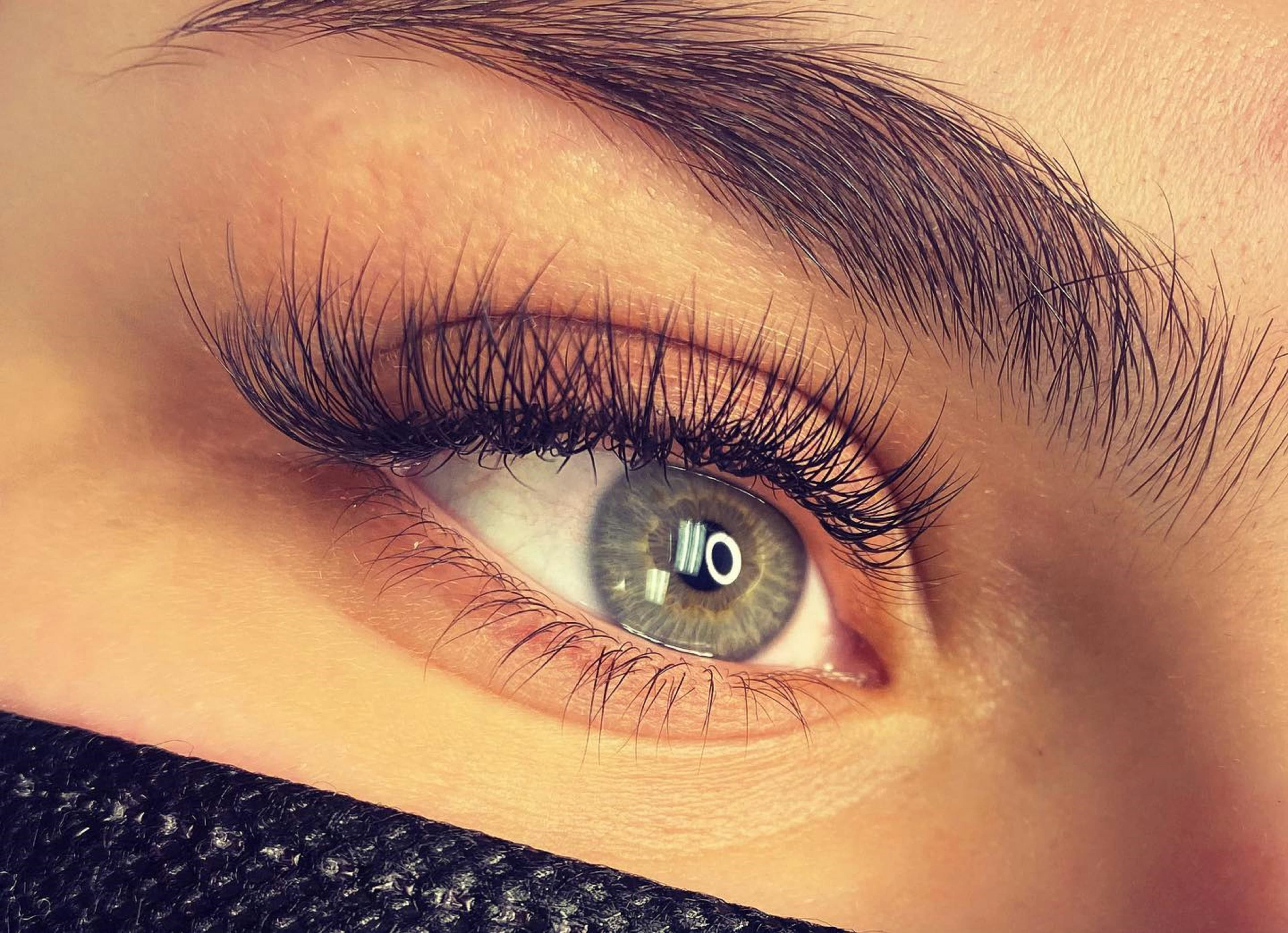 Aesthetic close-up of a client showing long, dark, thick styled eyelashes